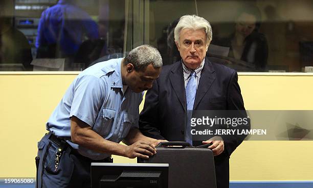 Security guard opens the suitcase of former Bosnian Serb leader Radovan Karadzic in the Hague on March 3, 2009 before Karadzic appears in court at...