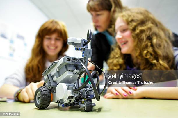 Two pupils and their teacher experimenting with a robot in a classroom at the Heinrich-Mann-School in the Neukoelln district of Berlin, Germany on...