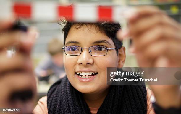 Pupil conducting an experiment on the topic of leverage in a physics lesson at the Heinrich-Mann-School in the Neukoelln district of Berlin, Germany...