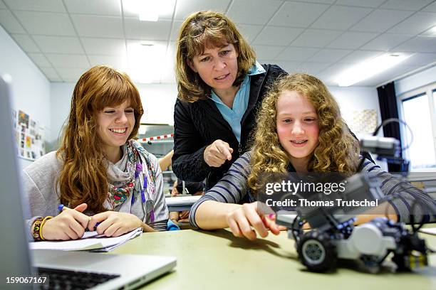 Two pupils and their teacher experimenting with a robot in a classroom at the Heinrich-Mann-School in the Neukoelln district of Berlin, Germany on...