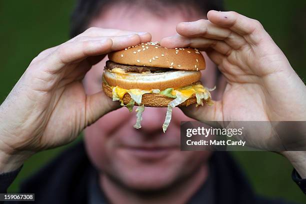 In this photo-illustration a man holds a burger purchased from a fast food outlet on January 7, 2013 in Bristol, England. A government-backed TV...