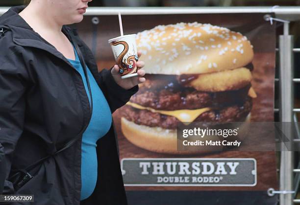 Woman passes an advertisement outside a fast food outlet on January 7, 2013 in Bristol, England. A government-backed TV advert - made by Aardman, the...