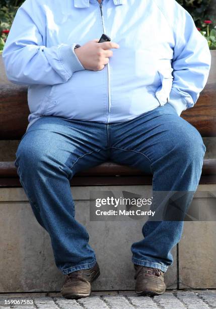 Man holds his mobile phone as he sits on a bench on January 7, 2013 in Bristol, England. A government-backed TV advert - made by Aardman, the...