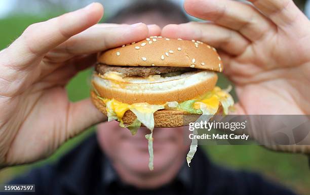 In this photo-illustration a man holds a burger from a fast food outlet on January 7, 2013 in Bristol, England. A government-backed TV advert - made...