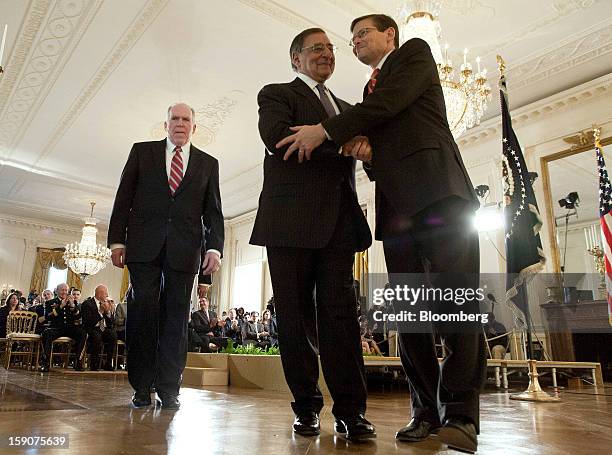 Leon Panetta, center, U.S. Secretary of defense, shakes hands with Michael J. Morell, right, acting director of the Central Intelligence Agency, as...