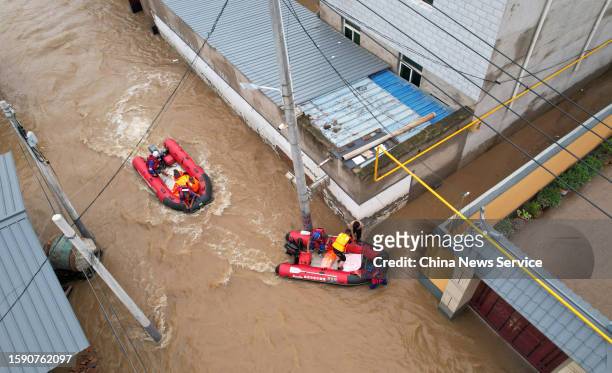 Rescuers use rubber boats to transfer trapped people after days of downpours brought by Typhoon Doksuri on August 3, 2023 in Zhuozhou, Hebei Province...