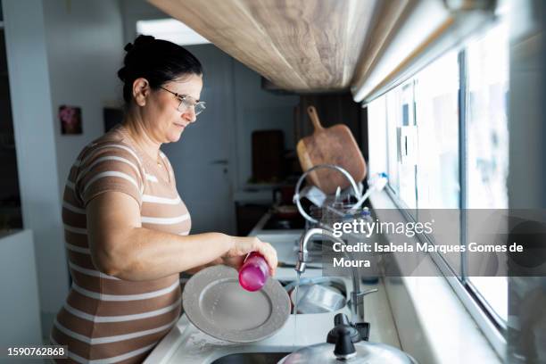donna che lava i piatti nella sua cucina - lady-moura foto e immagini stock