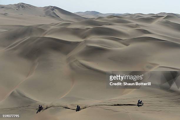 Riders cross the dunes during the stage from Pisco to Nazca on day three of the 2013 Dakar Rally on January 7, 2013 in Pisco, Peru.