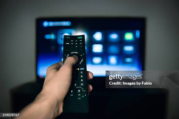 male hand using tv remote control - remote stock-fotos und bilder