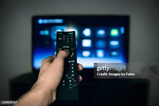 male hand using tv remote control - afstandsbediening stockfoto's en -beelden