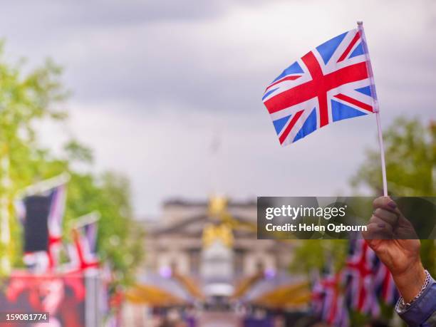 waving a union jack flag - waving flags stock pictures, royalty-free photos & images