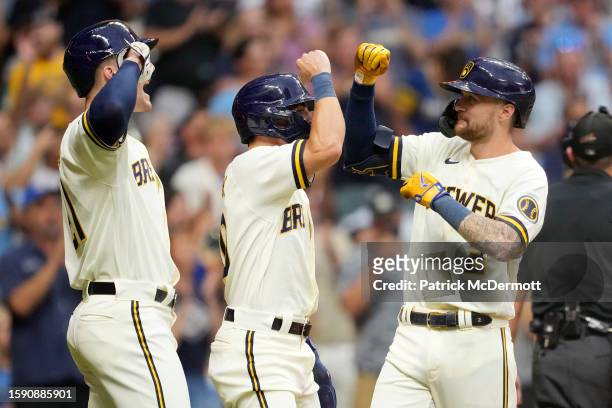 Brice Turang of the Milwaukee Brewers celebrates with Sal Frelick and Mark Canha after hitting a three-run home run in the fifth inning against the...