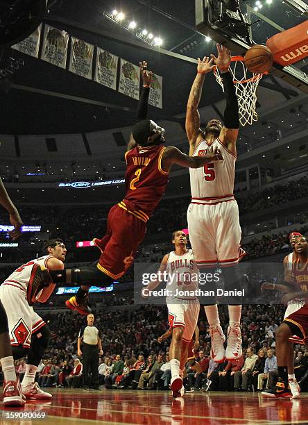 Kyrie Irving of the Cleveland Cavaliers looses the ball after being fouled by Kirk Hinrich of the Chicago Bulls as Carlos Boozer defends at the...