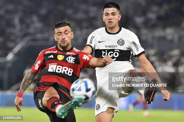 Flamengo's Uruguayan midfielder Giorgian de Arrascaeta fights for the ball with Olimpia's defender Mateo Gamarra during the Copa Libertadores round...
