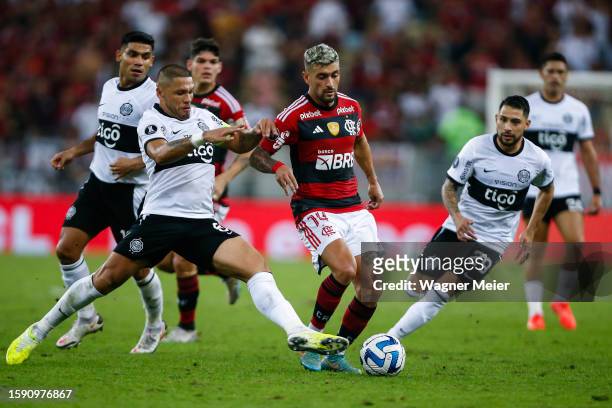 Richard Ortiz of Olimpia challenges for the ball with Giorgian De Arrascaeta of Flamengo during the Copa CONMEBOL Libertadores round of 16 first leg...