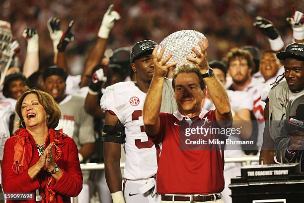 Head coach Nick Saban of the Alabama Crimson Tide celebrates with the BCS Coaches' Trophy as his wife Terry looks on after defeating the Notre Dame...