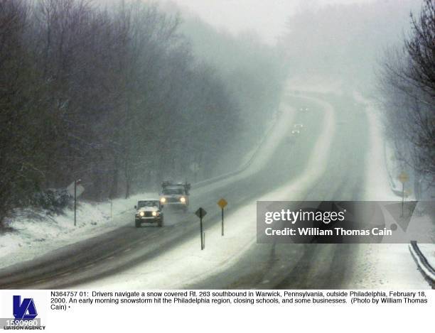 Drivers navigate a snow covered Rt. 263 southbound in Warwick, Pennsylvania, outside Philadelphia, February 18, 2000. An early morning snowstorm hit...