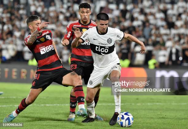 Flamengo's Uruguayan midfielder Giorgian de Arrascaeta fights for the ball with Olimpia's defender Mateo Gamarra during the Copa Libertadores round...