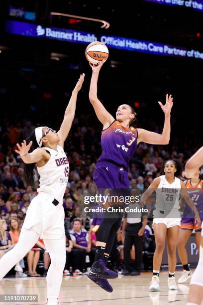 Guard Diana Taurasi of the Phoenix Mercury attempts a shot over guard Allisha Gray of the Atlanta Dream during the first half at Footprint Center on...