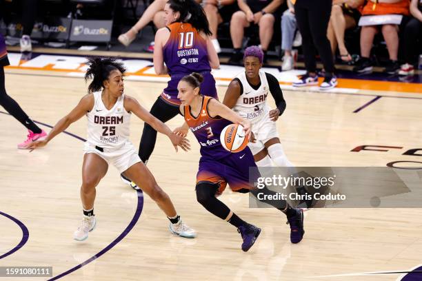 Guard Diana Taurasi of the Phoenix Mercury drives against forward Monique Billings of the Atlanta Dream and guard Danielle Robinson during the first...