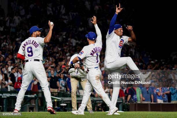 Jeimer Candelario, Nick Madrigal and Christopher Morel of the Chicago Cubs celebrate after the win over the Cincinnati Reds at Wrigley Field on...