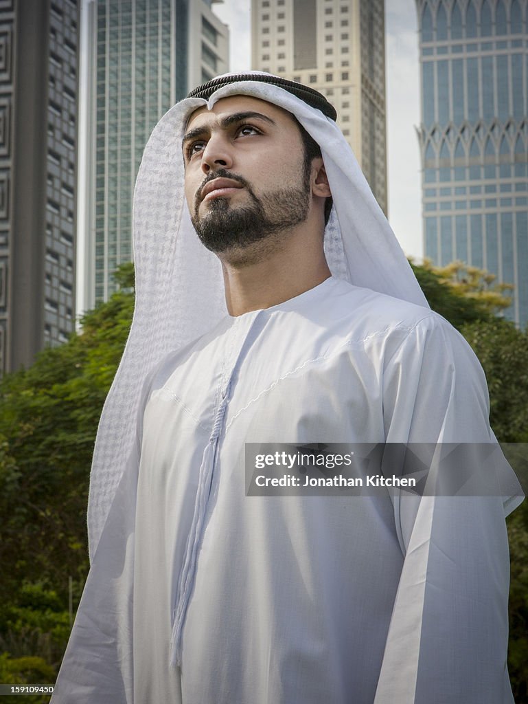 Middle eastern man stands in front of buildings