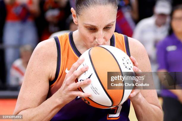 Guard Diana Taurasi of the Phoenix Mercury kisses the game ball after scoring her 10,000th career point during the second half against the Atlanta...