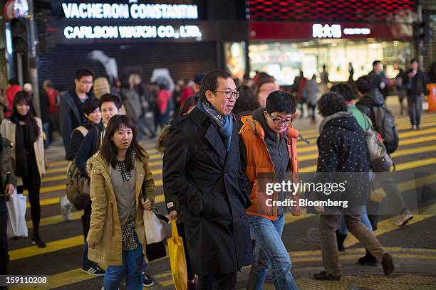 Pedestrians cross a road in the central business district of Hong Kong, China, on Friday, Jan. 4, 2013. Chief Executive Leung Chun-ying, who has been...