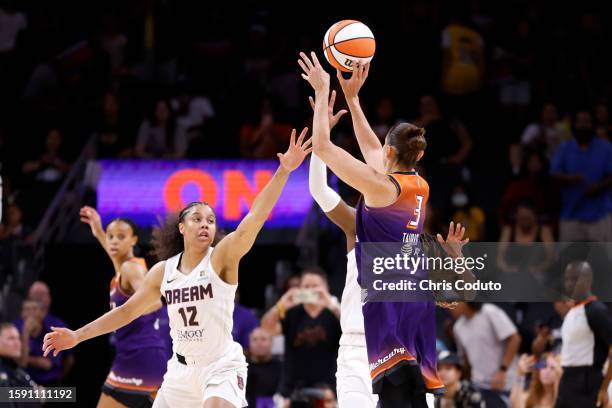 Guard Diana Taurasi of the Phoenix Mercury attempts a shot over forward Nia Coffey of the Atlanta Dream to score her 10,000th career point during the...