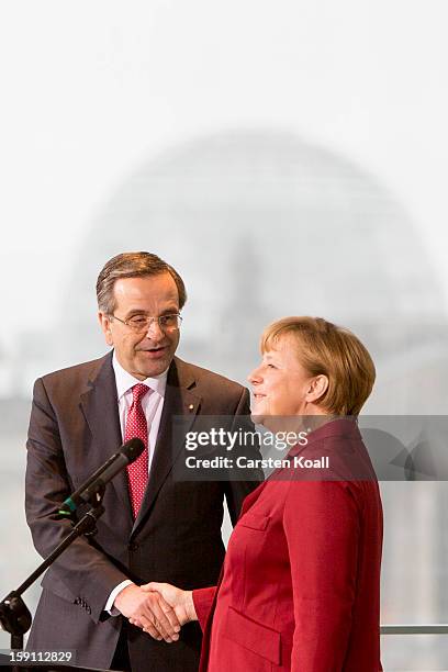 German Chancellor Angela Merkel and Greek Prime Minister Antonis Samaras shake hands after giving statements to the media following a meeting between...