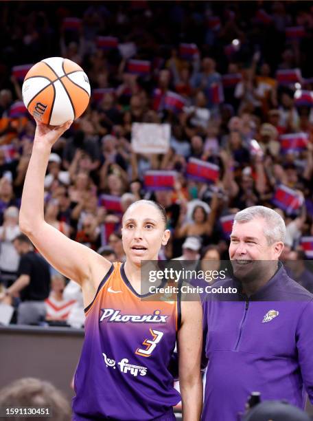 Guard Diana Taurasi of the Phoenix Mercury reacts with former Phoenix Mercury general manager Jim Pitman after scoring her 10,000th career point...