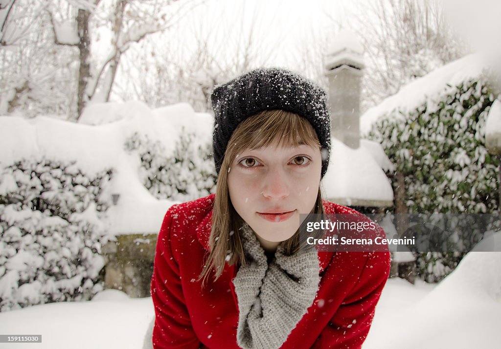 Young Girl in a red coat under the snow