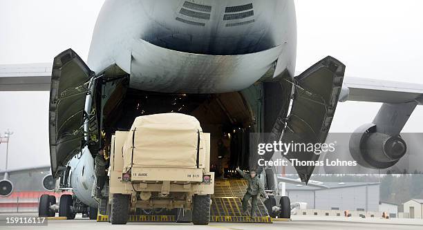 Soldiers of the U.S. Army Europe's 10th Army Air and Missile Defense Command, who operate Patriot anti-missile systems, load cargo on board a plane...