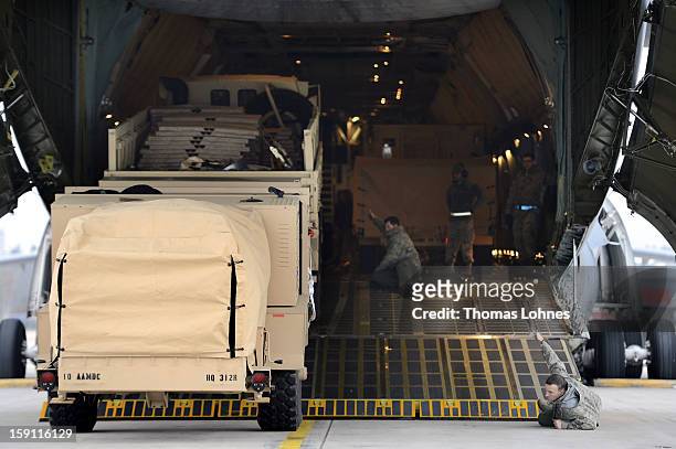 Soldiers of the U.S. Army Europe's 10th Army Air and Missile Defense Command, who operate Patriot anti-missile systems, load cargo on board a plane...