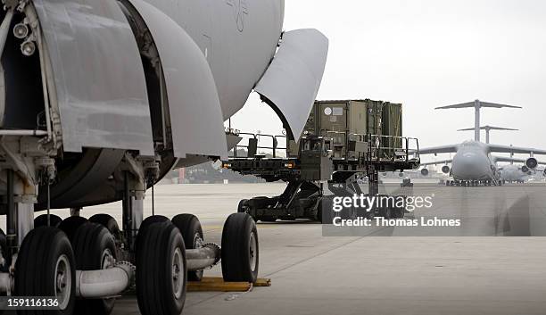 Soldiers of the U.S. Army Europe's 10th Army Air and Missile Defense Command, who operate Patriot anti-missile systems, load cargo on board a plane...