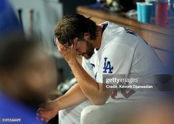 Clayton Kershaw of the Los Angeles Dodgers sits in the dugout at the end of the fifth inning against the Colorado Rockies at Dodger Stadium on August...