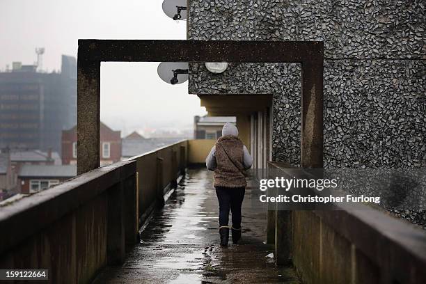 Woman walks along an elevated walkway on the Falinge Estate, which has been surveyed as the most deprived area in England for a fifth year in a row,...