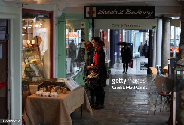 People browse in shops along the main shopping street of Totnes on January 8, 2013 in Totnes, England. The Devon town is renowned for its belief in...