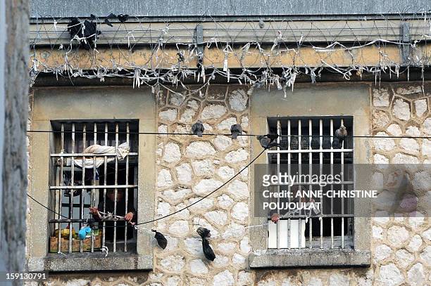 Detainees exchange small bags through the window of their cells at the Baumettes prison in Marseille, southern France, on January 8, 2013. French...