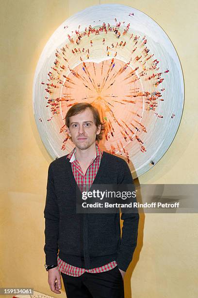 Photographer Charles Maze poses by one of his photographs during the 'Sorcieres' exhibition preview at Galerie Pierre Passebon on January 8, 2013 in...