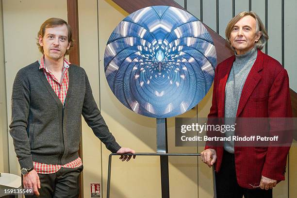 Photographer Charles Maze and gallery owner Pierre Passebon pose by one of Maze's photographs during the 'Sorcieres' exhibition preview at Galerie...