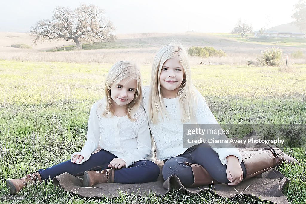 Sister sitting on blanket field oak tree blond