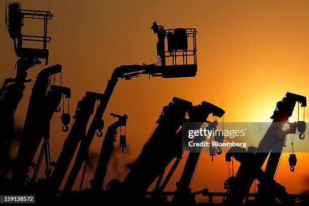 Cranes and boom lifts stand at an equipment rental company near a construction site in Tokyo, Japan, on Tuesday, Jan. 8, 2013. Prime Minister Shinzo...