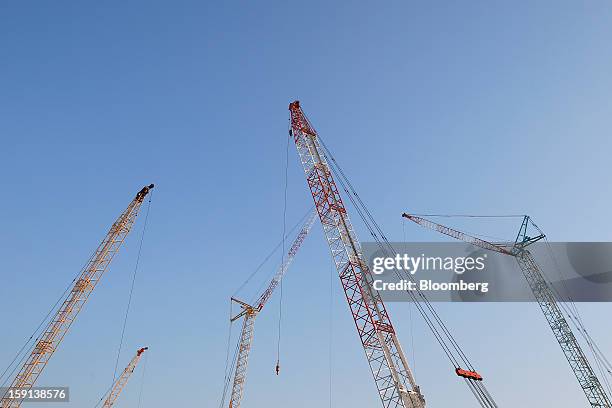 Cranes operate on a construction site in Tokyo, Japan, on Tuesday, Jan. 8, 2013. Prime Minister Shinzo Abe aims to compile Japan's economic stimulus...