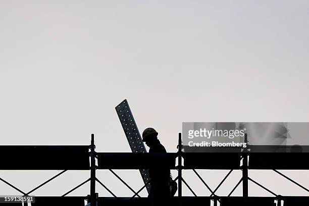 Worker labors on a construction site for a hospital in Tokyo, Japan, on Tuesday, Jan. 8, 2013. Prime Minister Shinzo Abe aims to compile Japan's...