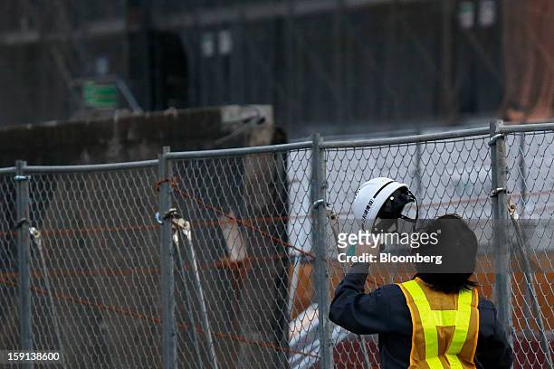 Worker removes his safety hat on a construction site for a hospital in Tokyo, Japan, on Tuesday, Jan. 8, 2013. Prime Minister Shinzo Abe aims to...
