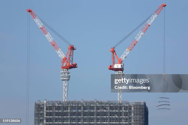 Cranes operate on a construction site in Tokyo, Japan, on Tuesday, Jan. 8, 2013. Prime Minister Shinzo Abe aims to compile Japan's economic stimulus...