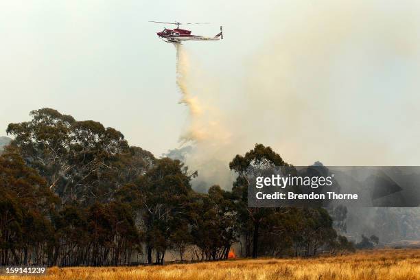 Water-bombing operations take place on a fire at Sandhills on January 9, 2013 in Bungendore, Australia. Temperatures cooled overnight offering relief...