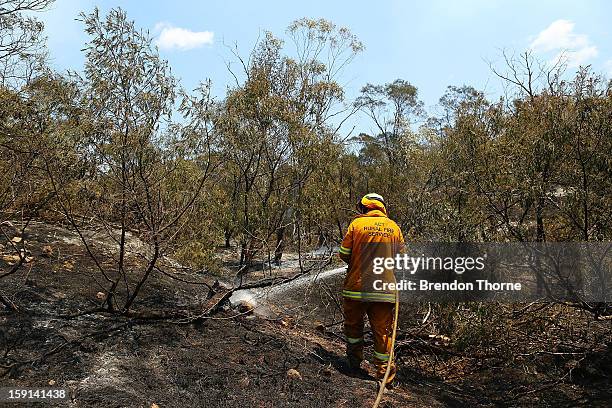 Rural Fire Service member 'mops-up' spot fires at Sandhills on January 9, 2013 in Bungendore, Australia. Temperatures cooled overnight offering...