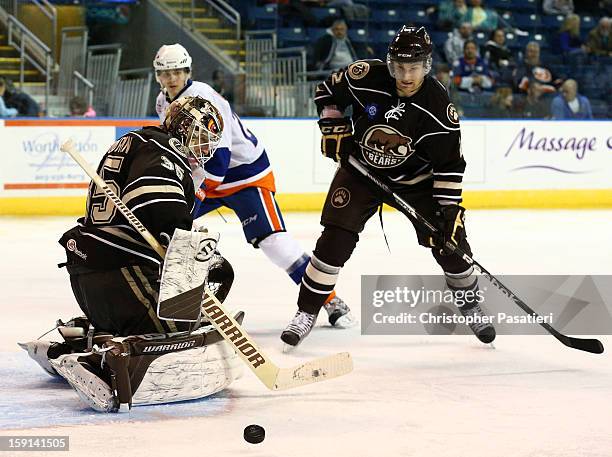 Dany Sabourin of the Hershey Bears makes a save as teammate Patrick McNeill and David Ullstrom of the Bridgeport Sound Tigers wait for the rebounded...